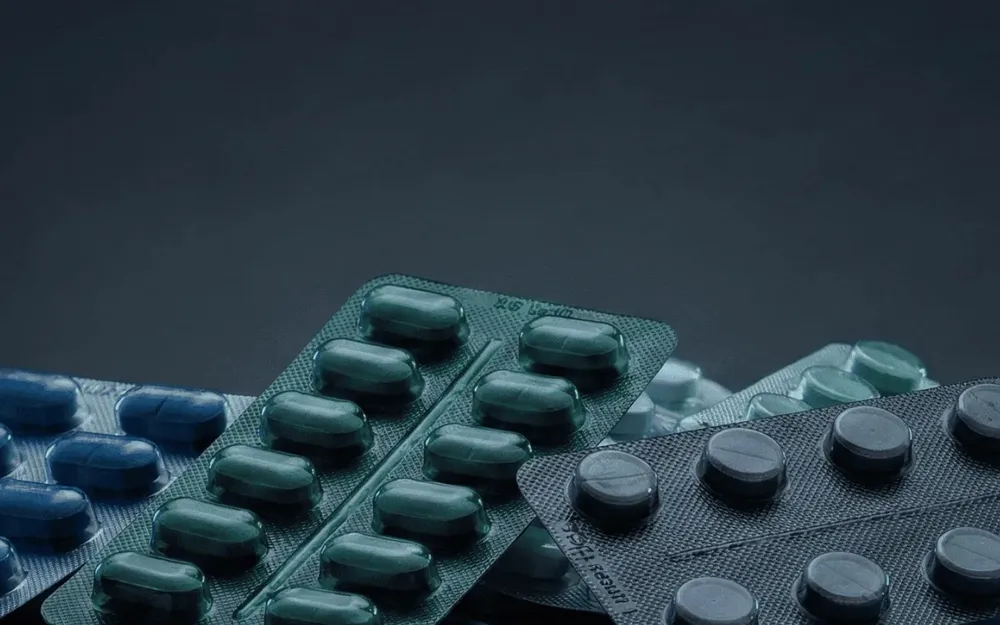 Plaquettes de comprimés et gélules sur fond sombre, visuel d'accueil de l'application SafePills.
